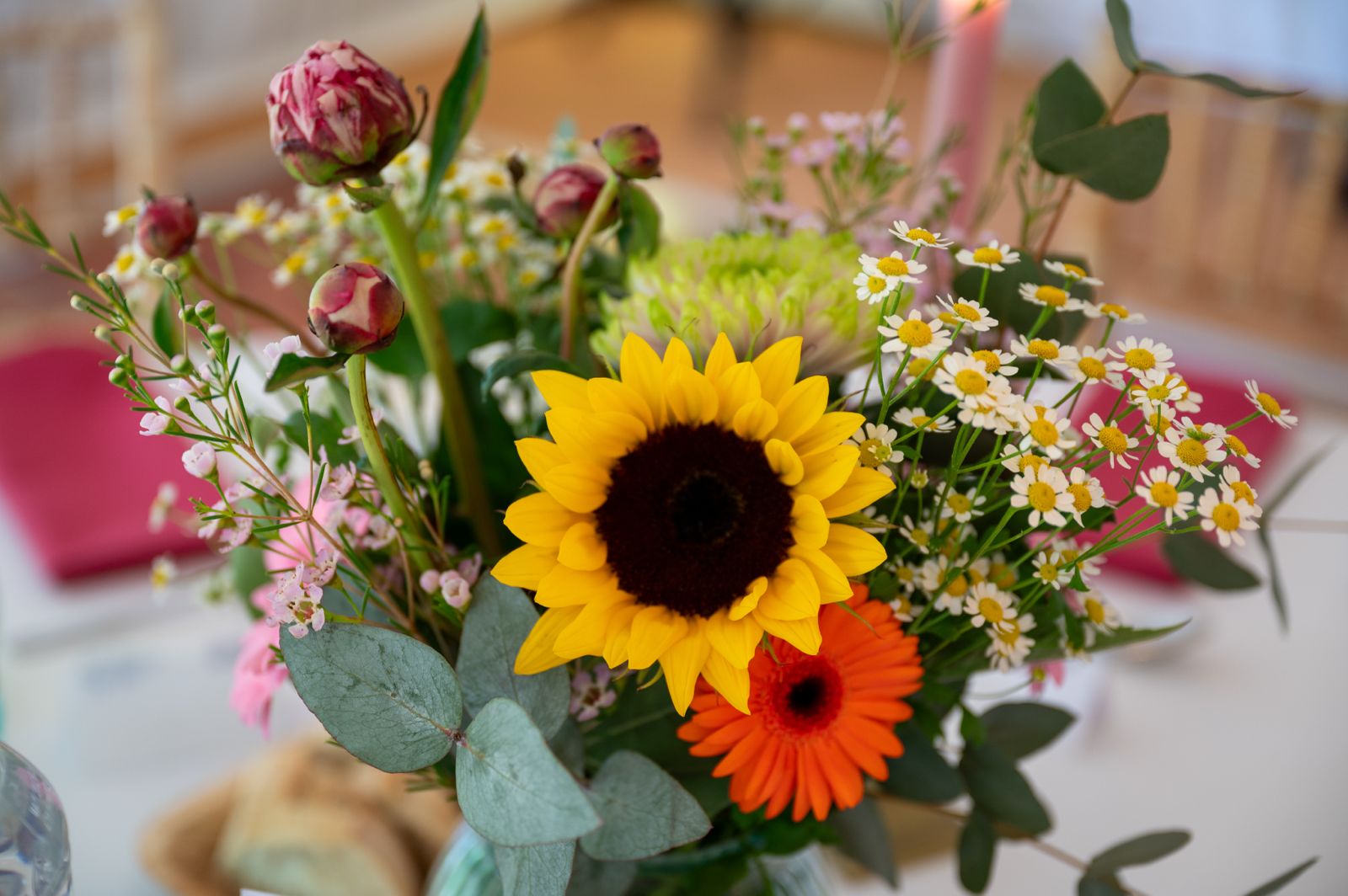 Colourful seasonal floral centrepiece with sunflower, gerbera and roses