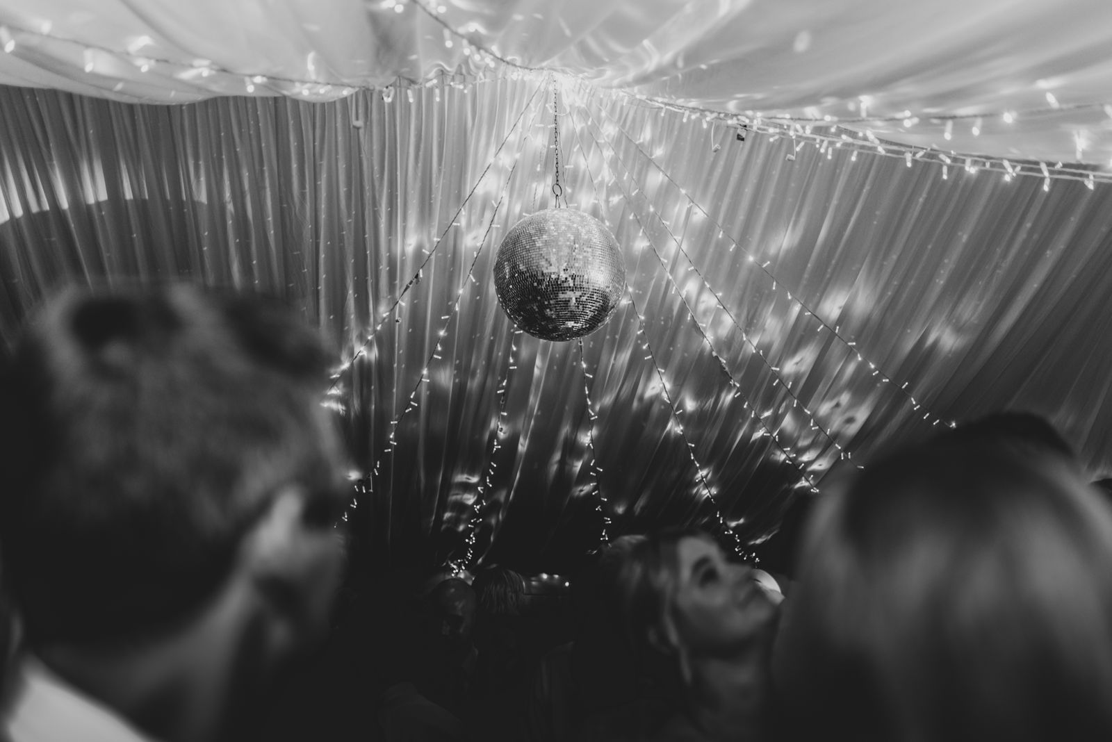 Mirror ball under a fairy-lit marquee ceiling on the dance floor