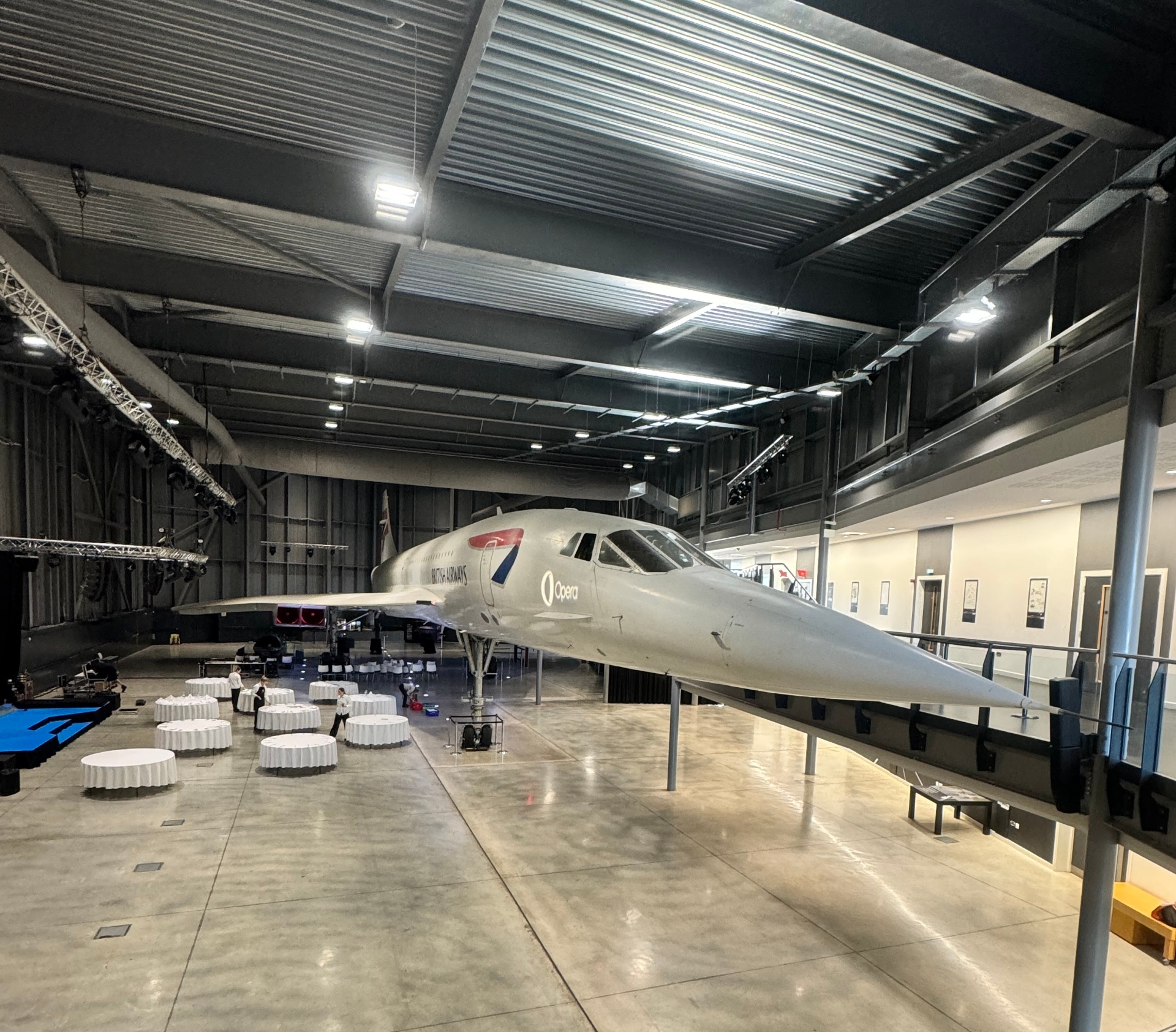 British Airways Concorde aircraft displayed in hangar event space with banquet tables set for a reception