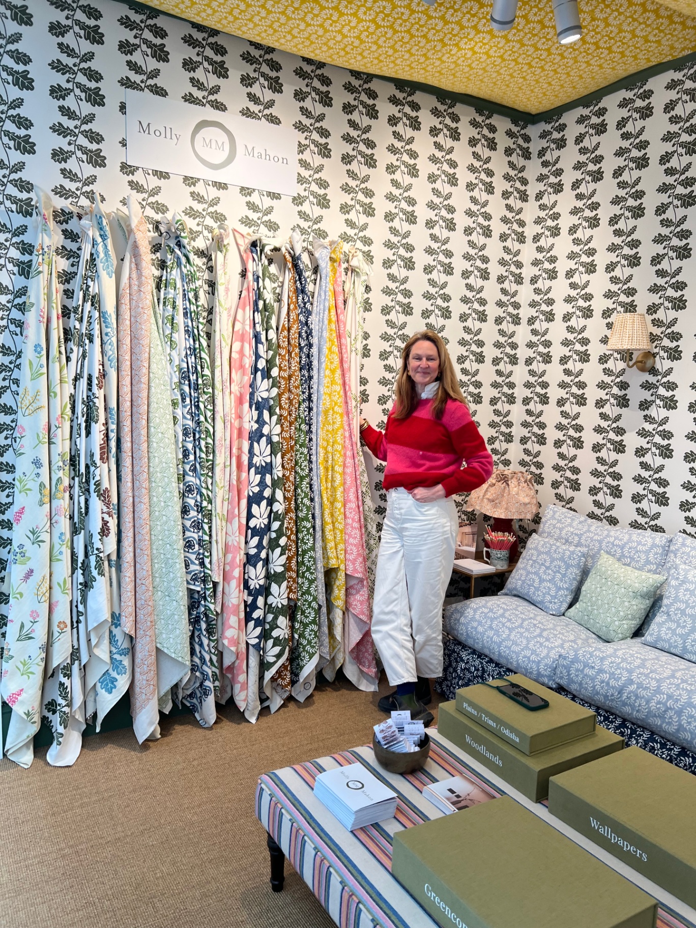 Molly Mahon stand with fabric display and founder in front of patterned wallpaper