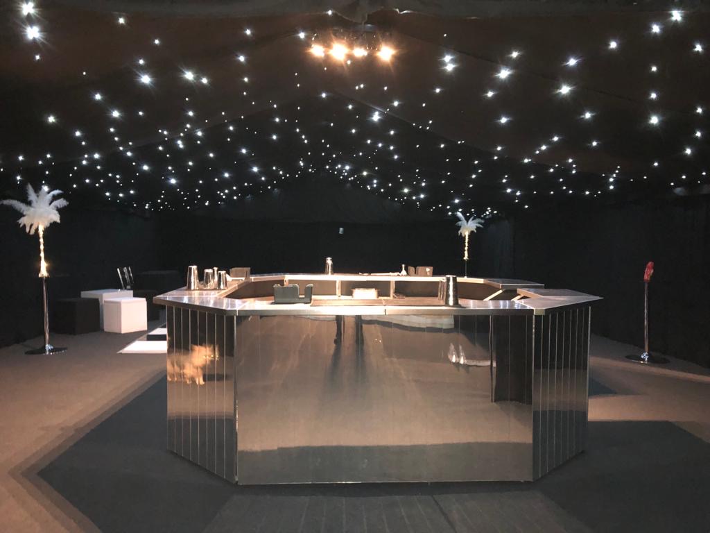 Mirrored hexagonal bar under a starlit marquee ceiling
